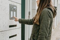 The girl pushes the doorphone button or calls the intercom Royalty Free Stock Photography The girl pushes the doorphone button or calls the intercom Royalty Free Stock Photography