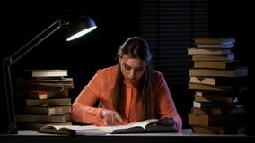 Girl reads and writes information in a notebook. Black background stock video footage Girl reads and writes information in a notebook. Black background stock video footage