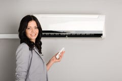 Girl with a remote control air conditioner stock photo Girl with a remote control air conditioner stock photo