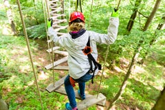Girl seen from above climbing in high rope course Royalty Free Stock Images Girl seen from above climbing in high rope course Royalty Free Stock Images