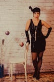 A girl with short black hair with a bandage with sequins and feathers on her head in a dress with sequins in the Chicago royalty free stock image A girl with short black hair with a bandage with sequins and feathers on her head in a dress with sequins in the Chicago royalty free stock image