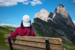 A young traveler on the bench with the background of Seceda peak stock images A young traveler on the bench with the background of Seceda peak stock images