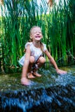 Girl Sitting In Water Near Small Waterfall Stock Images