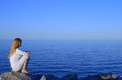 Girl Sitting On The Rock By The Peaceful Sea Stock Images Girl Sitting On The Rock By The Peaceful Sea Stock Images