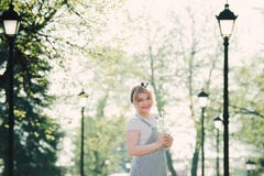 Girl with a sprig of cherry blossoms in her hands. She enjoys th royalty free stock photography Girl with a sprig of cherry blossoms in her hands. She enjoys th royalty free stock photography