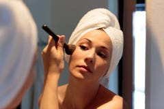 Woman in front of the mirror who is putting on make-up before going out at night royalty free stock images Woman in front of the mirror who is putting on make-up before going out at night royalty free stock images