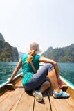 Girl traveler looks at the exotic island while sitting in a boat royalty free stock photos Girl traveler looks at the exotic island while sitting in a boat royalty free stock photos