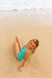 Girl in a turquoise one-piece swim suit sitting on the sandy beach royalty free stock photos Girl in a turquoise one-piece swim suit sitting on the sandy beach royalty free stock photos