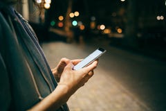 Girl typing message on smart phone on background bokeh lights stock photography Girl typing message on smart phone on background bokeh lights stock photography
