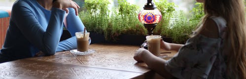 Girlfriends enjoying in cafe together. Young women meeting in a cafe. meeting two women in a cafe for coffee. blue dress, dress in royalty free stock image Girlfriends enjoying in cafe together. Young women meeting in a cafe. meeting two women in a cafe for coffee. blue dress, dress in royalty free stock image