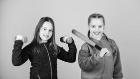 Girls cute kids with sport equipment dumbbells and baseball bat. We love sport. Child might excel in completely royalty free stock photography Girls cute kids with sport equipment dumbbells and baseball bat. We love sport. Child might excel in completely royalty free stock photography