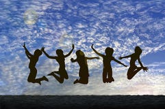 Girls Jumping With Joy On The Beach Silhouetted Against A Cloudy Sky Stock Images Girls Jumping With Joy On The Beach Silhouetted Against A Cloudy Sky Stock Images
