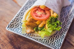 Girocompases griegos envueltos en un pan Pita en un fondo de madera fotos de archivo libres de regalías Girocompases griegos envueltos en un pan Pita en un fondo de madera fotos de archivo libres de regalías
