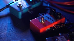 Gitaarpedalen en footswitch de ruimte van de binnenkantopname Sluit omhoog van gitaarpedalen en musicus` s voet die op het onttre stock footage Gitaarpedalen en footswitch de ruimte van de binnenkantopname Sluit omhoog van gitaarpedalen en musicus` s voet die op het onttre stock footage