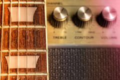 Gitarre fretboard und Gitterwerkmarkierungsdetail, unscharfe alte Verstärkergriffe im Hintergrund lizenzfreies stockbild Gitarre fretboard und Gitterwerkmarkierungsdetail, unscharfe alte Verstärkergriffe im Hintergrund lizenzfreies stockbild