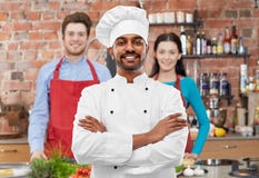 Gl?cklicher m?nnlicher indischer Chef im Toque am Kochkurs stockfotografie Gl?cklicher m?nnlicher indischer Chef im Toque am Kochkurs stockfotografie