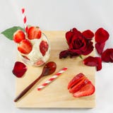 Glace de fraise, fleur rose et cuillère sur des élém. de conseil en bois photographie stock Glace de fraise, fleur rose et cuillère sur des élém. de conseil en bois photographie stock