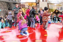 Glade barn hoppar gyckel på en röd uppblåsbar trampolin arkivfoto Glade barn hoppar gyckel på en röd uppblåsbar trampolin arkivfoto