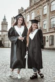 Glade flickor som har avläggande av examenpartiet på universitetet arkivbilder Glade flickor som har avläggande av examenpartiet på universitetet arkivbilder