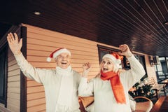 Gladlynt äldre par som bär röda lock för jul royaltyfria bilder Gladlynt äldre par som bär röda lock för jul royaltyfria bilder