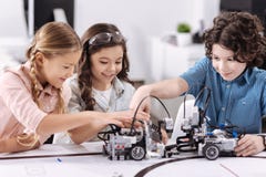 Gladlynta ungar som arbetar på techprojektet på skolan royaltyfri fotografi Gladlynta ungar som arbetar på techprojektet på skolan royaltyfri fotografi