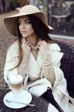 Glamour girl with dark straight hair wears luxurious beige coat with elegant hat royalty free stock images Glamour girl with dark straight hair wears luxurious beige coat with elegant hat royalty free stock images