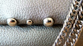 Glanzende klinknagels en een ketting tegen een zilverachtige huid stock foto's Glanzende klinknagels en een ketting tegen een zilverachtige huid stock foto's