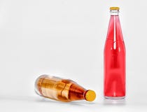 Glasflaschen mit rotem und gelbem Getränk auf einem weißen Hintergrund Front View lizenzfreie stockfotografie Glasflaschen mit rotem und gelbem Getränk auf einem weißen Hintergrund Front View lizenzfreie stockfotografie
