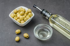 Glass Bottle Of Olive Oil And Olive In A White Bowl On A Dark Background. Top View. Olive Oil Concept Royalty Free Stock Photos