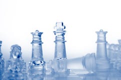 Glass Chess Pieces With Blue Light Stock Image