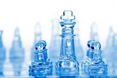 Glass Chess Pieces With Blue Light Stock Photography