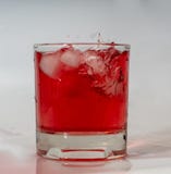 A glass with a drink and ice. Ice falling in stock photo A glass with a drink and ice. Ice falling in stock photo