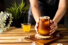 Glass of espresso with orange juice on wooden table and copy space, Summer Cocktail, Cold brew coffee or black tea. Close up, selective focus