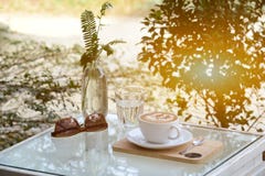 Glass of water and coffee and sunglasses on table with outdoor stock photo Glass of water and coffee and sunglasses on table with outdoor stock photo