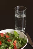 A glass of water with light tomato salad in white china bowl stock photos A glass of water with light tomato salad in white china bowl stock photos