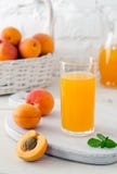 Glass With Apricot Juice And Apricot Fruits In Basket Royalty Free Stock Image