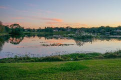 Gli alberi e un piccolo stagno formano la riflessione perfetta al tramonto Immagine Stock Gli alberi e un piccolo stagno formano la riflessione perfetta al tramonto Immagine Stock