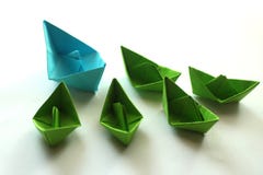 Gli origami incartano le navi nei colori blu-chiaro e verdi fotografie stock Gli origami incartano le navi nei colori blu-chiaro e verdi fotografie stock