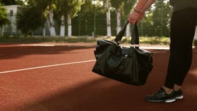 Gli sport di trasporto della giovane donna graziosa di forma fisica insaccano mentre camminano dallo stadio di aria aperta Nessun archivi video Gli sport di trasporto della giovane donna graziosa di forma fisica insaccano mentre camminano dallo stadio di aria aperta Nessun archivi video