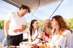 Gli uomini con tre belle ragazze sta bevendo il champagne sull'yacht immagine stock libera da diritti Gli uomini con tre belle ragazze sta bevendo il champagne sull'yacht immagine stock libera da diritti