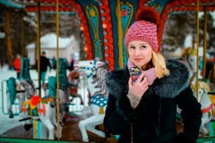 Glimlachend blond meisje in de winterkleren met mobiele telefoon in haar hand royalty-vrije stock afbeeldingen Glimlachend blond meisje in de winterkleren met mobiele telefoon in haar hand royalty-vrije stock afbeeldingen