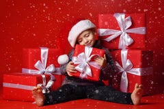 Glimlachend grappig kind in gift van de holdingskerstmis van de Kerstman de rode hoed ter beschikking Kerstmistak en klokken royalty-vrije stock foto's Glimlachend grappig kind in gift van de holdingskerstmis van de Kerstman de rode hoed ter beschikking Kerstmistak en klokken royalty-vrije stock foto's