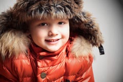 Glimlachend kind in bontkap en oranje de winterjacket.fashion jongen royalty-vrije stock afbeelding Glimlachend kind in bontkap en oranje de winterjacket.fashion jongen royalty-vrije stock afbeelding