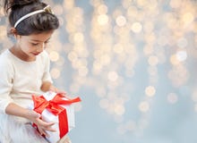 Glimlachend meisje met giftdoos over lichten royalty-vrije stock fotografie Glimlachend meisje met giftdoos over lichten royalty-vrije stock fotografie