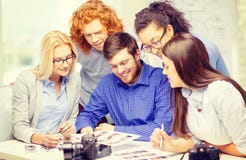 Glimlachend team met photocamera en beelden in bureau stock afbeelding Glimlachend team met photocamera en beelden in bureau stock afbeelding