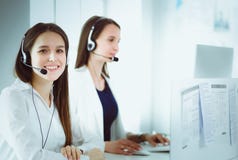 Glimlachende onderneemster of helpline exploitant met hoofdtelefoon en computer op kantoor Stock Foto Glimlachende onderneemster of helpline exploitant met hoofdtelefoon en computer op kantoor Stock Foto