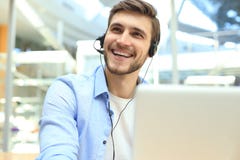 Glimlachende vriendschappelijke knappe jonge mannelijke call centreexploitant stock afbeelding Glimlachende vriendschappelijke knappe jonge mannelijke call centreexploitant stock afbeelding