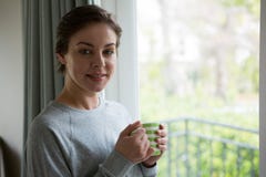 Glimlachende vrouw die kop van koffie hebben thuis stock afbeelding Glimlachende vrouw die kop van koffie hebben thuis stock afbeelding