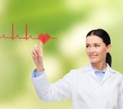 Glimlachende vrouwelijke arts die aan cardiogram richten royalty-vrije stock fotografie Glimlachende vrouwelijke arts die aan cardiogram richten royalty-vrije stock fotografie