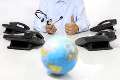 Globales internationales Stützkonzept, -kopfhörer und -büro rufen auf Schreibtisch mit Kugelkarte an Lizenzfreie Stockfotos Globales internationales Stützkonzept, -kopfhörer und -büro rufen auf Schreibtisch mit Kugelkarte an Lizenzfreie Stockfotos